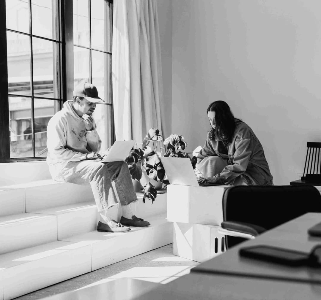 Diverse team collaborating around a table with laptops and notes
